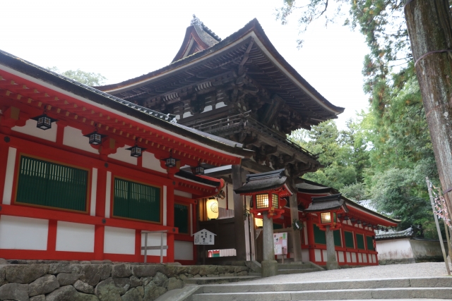 深い森から現れる石上神宮の朱塗りの楼門