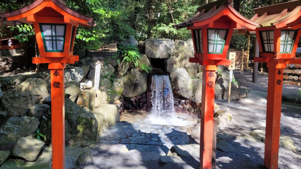 苔むした岩の間を静かに落ちる、小さな滝と周囲の森